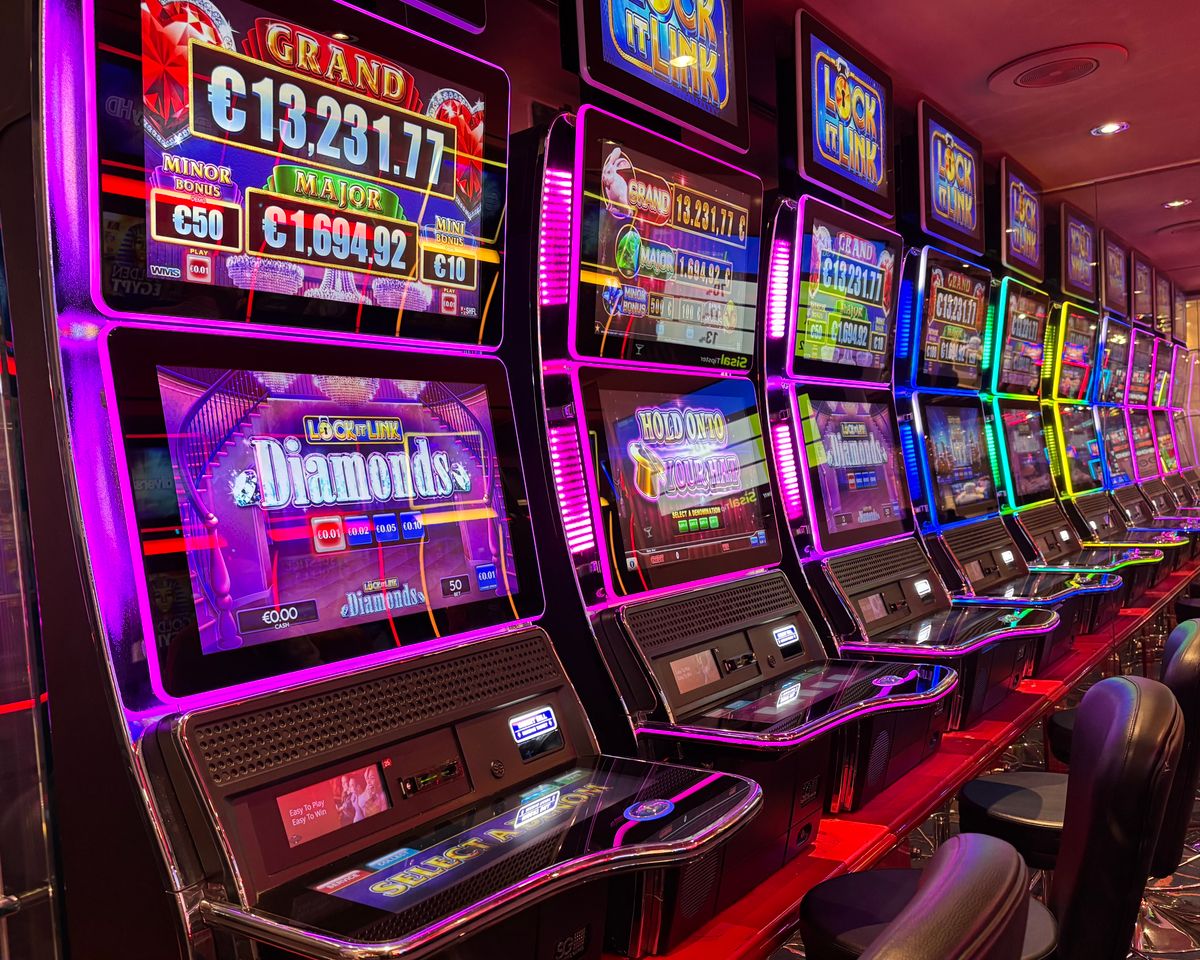 Mesin slot berwarna-warni dengan lampu neon di kasino