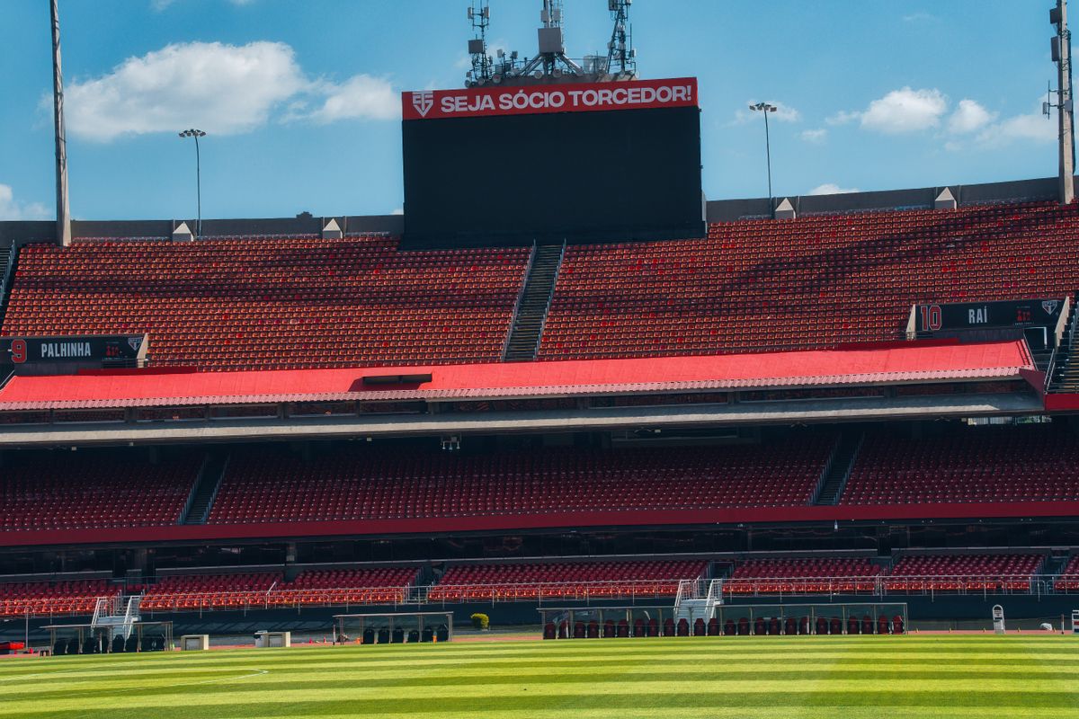 Stadion sepak bola kosong dengan papan skor dan lapangan hijau